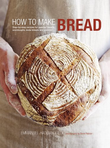 A person holding a round, scored loaf of crusty bread, book cover design.