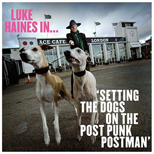 Album cover art: man in black coat and hat with two white dogs.