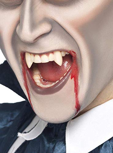 Person with pale skin and fake vampire fangs, with red “blood”.