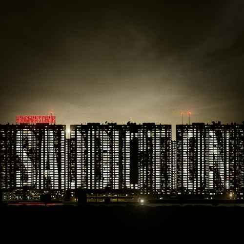 Cityscape with illuminated high-rise buildings and red "Hangman's Chair" text.