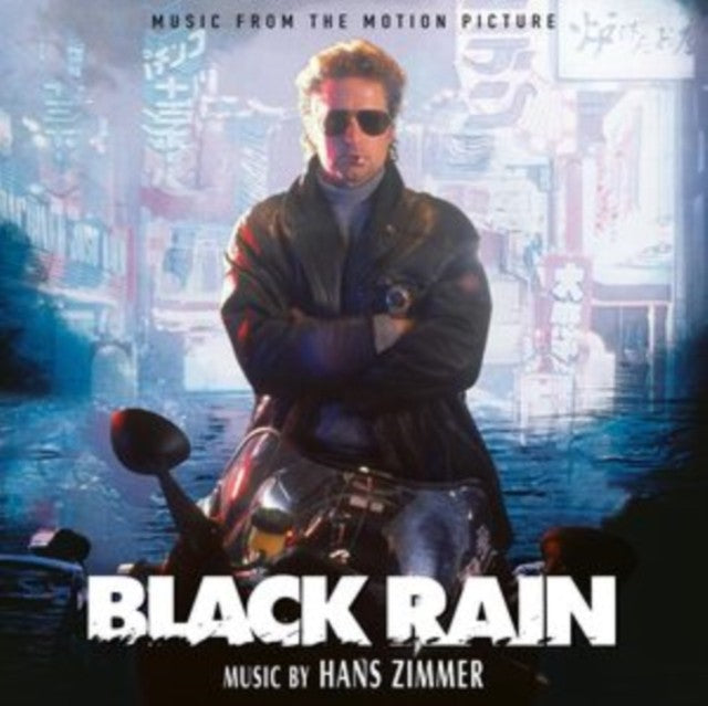 Michael Douglas wearing sunglasses on a motorcycle in front of a neon city street.