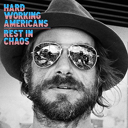 "Black and white album cover with a man wearing sunglasses and a hat."