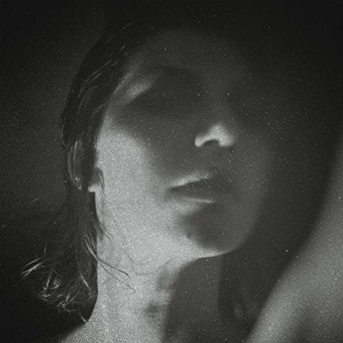 Black and white close-up portrait of a woman with her eyes closed.