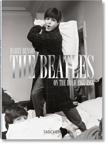 Black and white photo of Paul McCartney having a pillow fight on a bed.