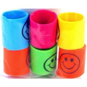 Colorful plastic slinkies stacked together, each with a black smiley face.