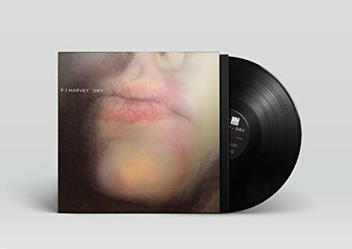 P J Harvey “Dry” vinyl record with a close-up face on the cover.