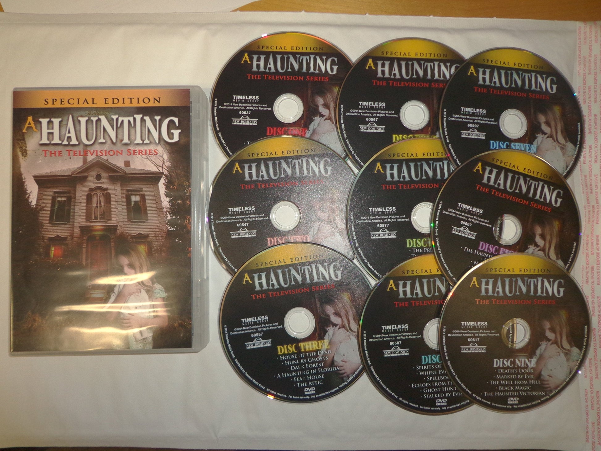 A Haunting" DVD set with case and nine discs featuring a haunted house.