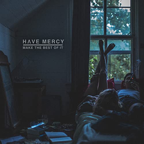 A couple relaxes in a dimly lit room with text reading Have Mercy Make The Best.