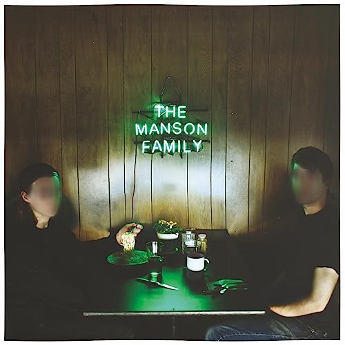Vinyl album cover: two figures at a table under a neon sign.