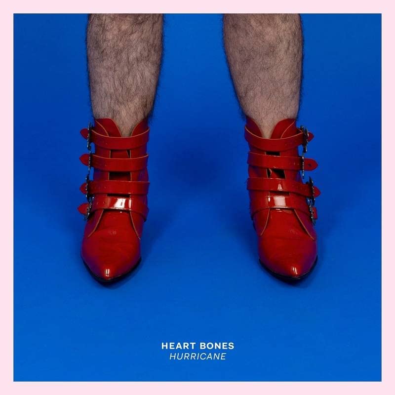 Hairy legs wearing red buckled boots against a solid blue background.