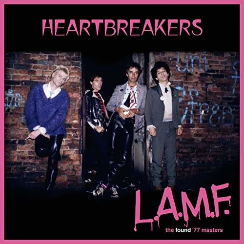 The band Heartbreakers posing against a brick wall on a pink-bordered album cover.