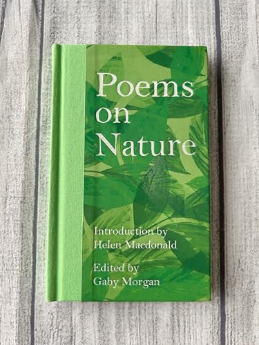 Green book titled Poems on Nature with a leaf pattern cover on wooden surface.