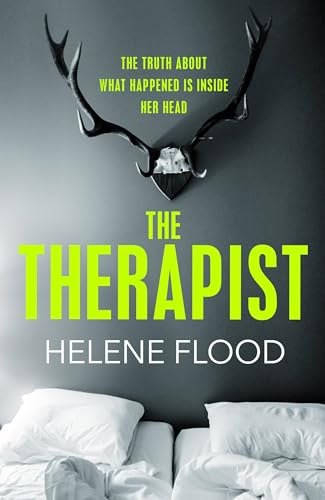Book cover with deer antlers mounted on a grey wall above two white pillows.