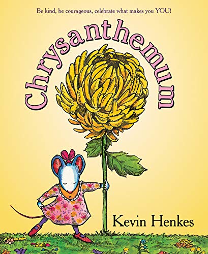 A mouse wearing a floral dress stands next to a large yellow chrysanthemum flower.