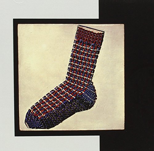 A woven red, white, and blue sock on a cream square against black background.
