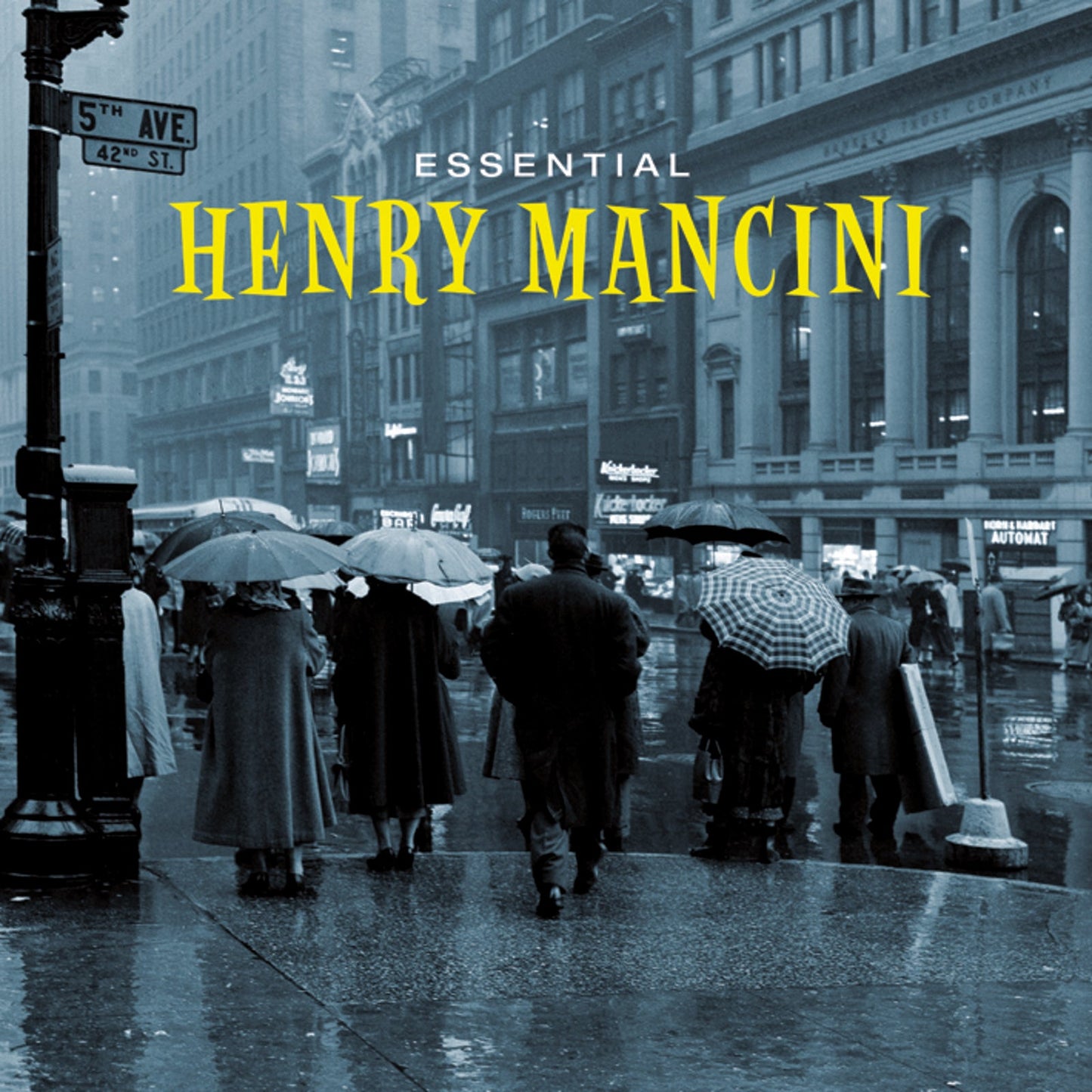 CD cover for Henry Mancini’s “Essential Henry Mancini” with a rainy street scene.