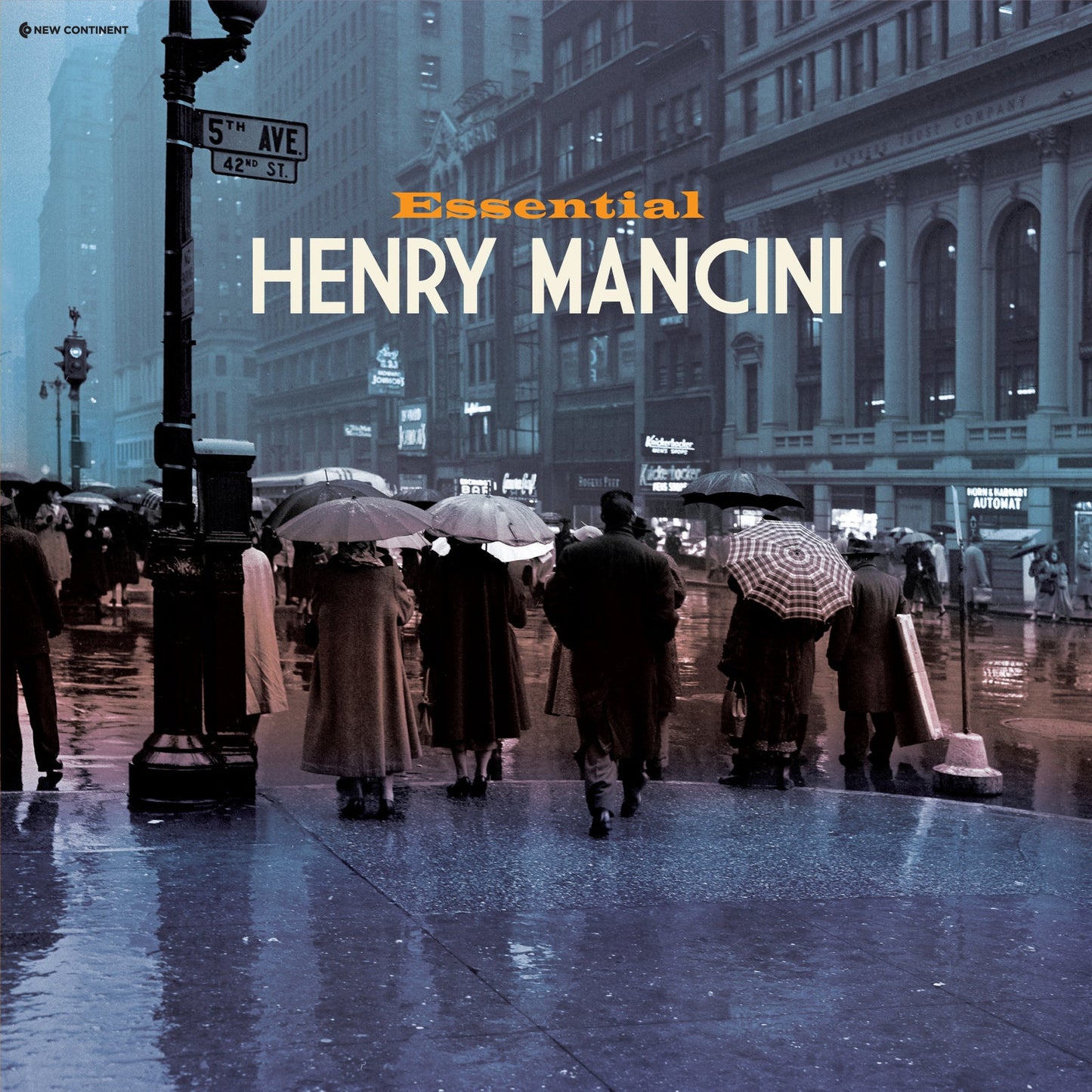 People with umbrellas walk down a rainy New York City street at 5th Avenue.