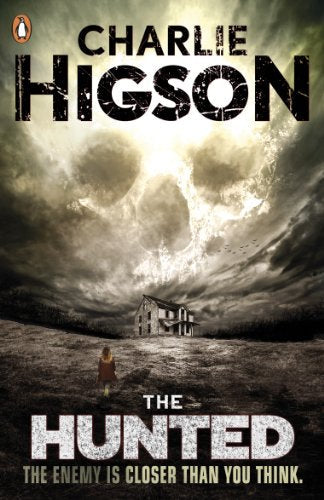 A person walks toward a house under a sky forming a giant, ghostly skull.