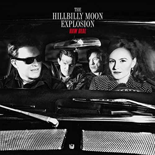 Black and white photo of four people inside a classic car.