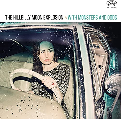 Woman in leopard print dress sitting in a vintage car during rain.
