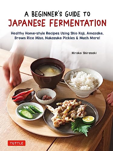 Cookbook cover with Japanese food including rice, soup, and grilled skewers.
