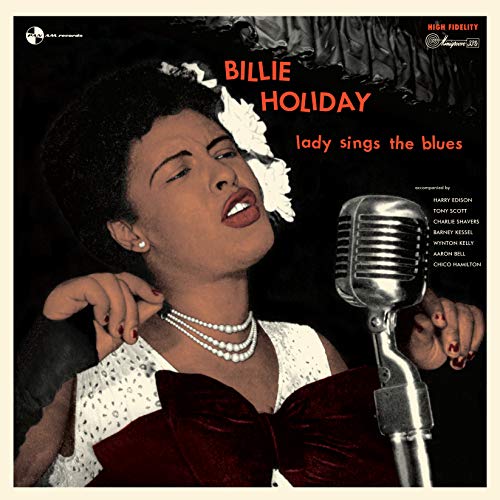 Billie Holiday in elegant attire with a white flower in her hair near a microphone.