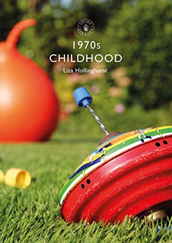 A spinning top on grass with a large orange toy in the background.