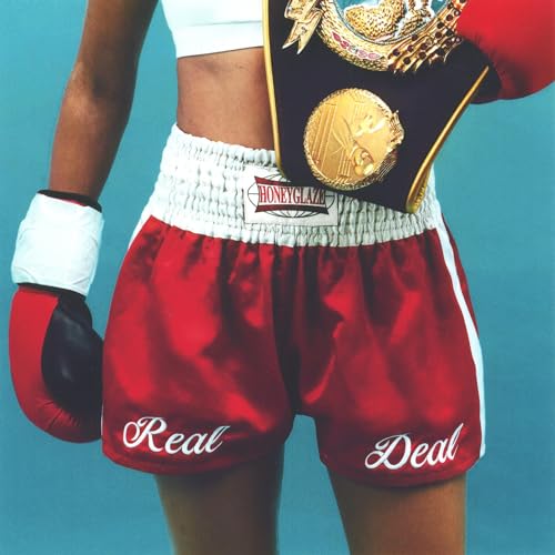A person wearing red boxing shorts with Real Deal text and a championship belt.