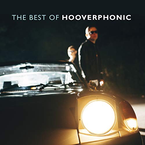 Two people stand behind a car with illuminated headlights at night under text title.