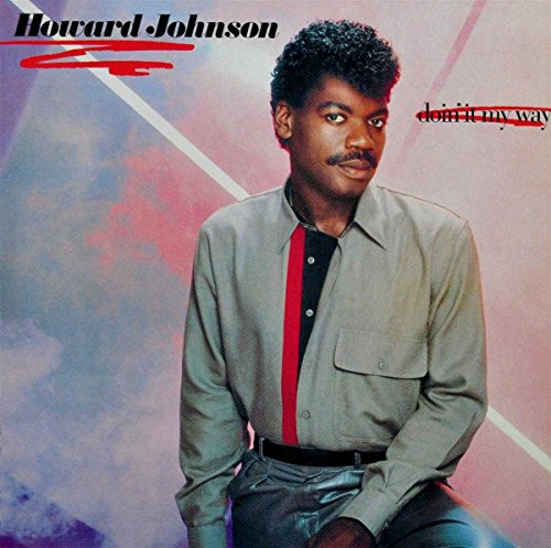 Howard Johnson wearing a gray shirt against a colorful, abstract geometric background.