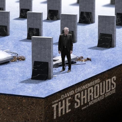 A man in a suit stands among stone grave markers on a blue surface.