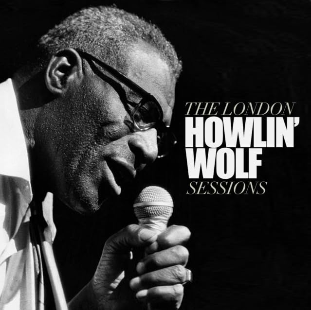 Black and white portrait of Howlin' Wolf holding a microphone.