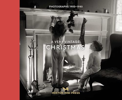 Black and white photo of children decorating a fireplace for Christmas.