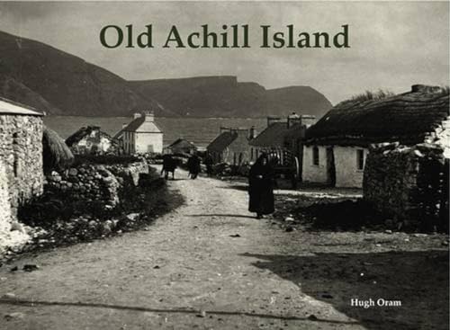 Black and white photo of a rural Irish village and mountains.