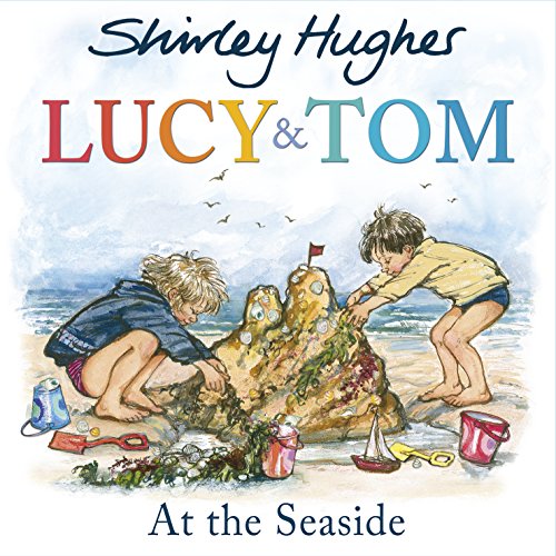 Two children building a sandcastle on a beach with toys.