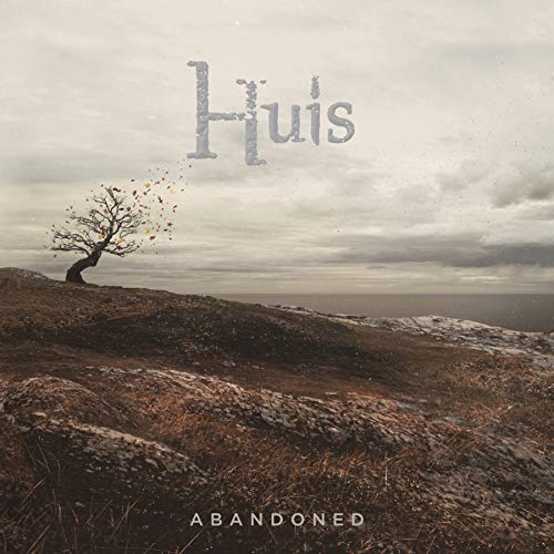 CD cover: barren landscape with a solitary tree under cloudy sky.