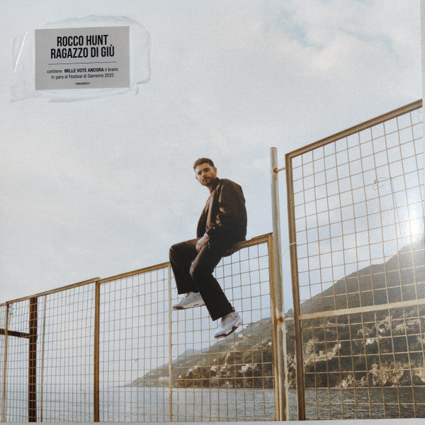 Vinyl record cover featuring Rocco Hunt posing on a metal fence.