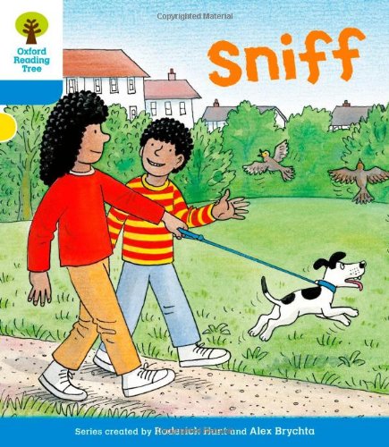 Two children walking a spotted dog on a grassy path.