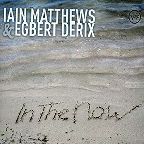 "CD cover with 'In The Now' written in sand, artist names above."