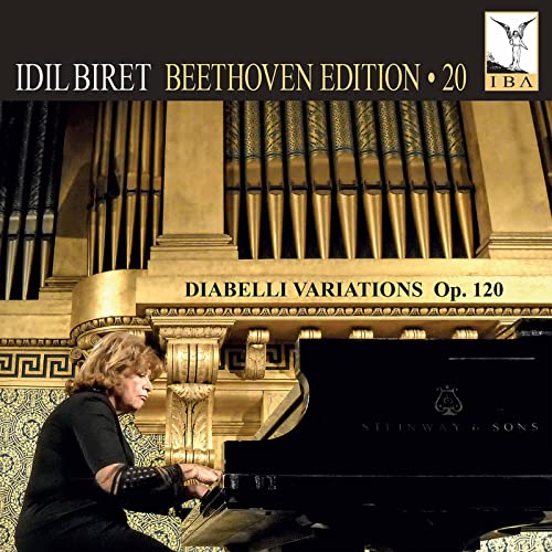 Pianist Idil Biret at a Steinway piano with organ pipes in background.