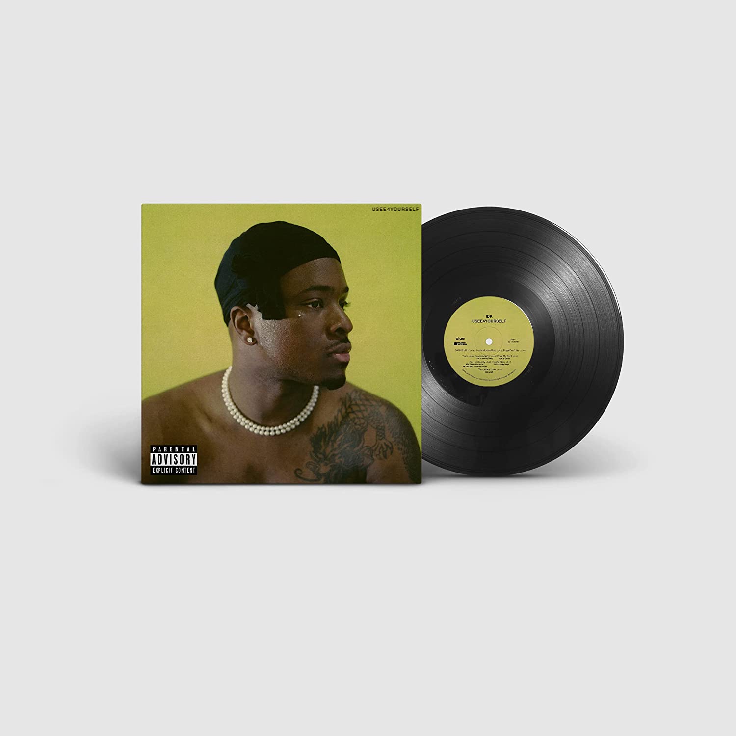 "Vinyl record with olive green cover featuring a man with a pearl necklace."