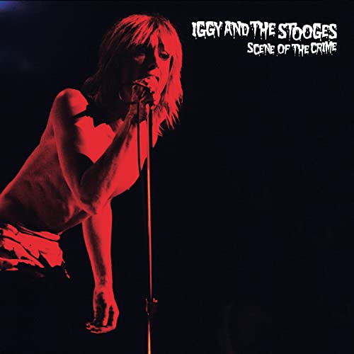 Red-tinted photo of Iggy Pop singing into a microphone against a black background.
