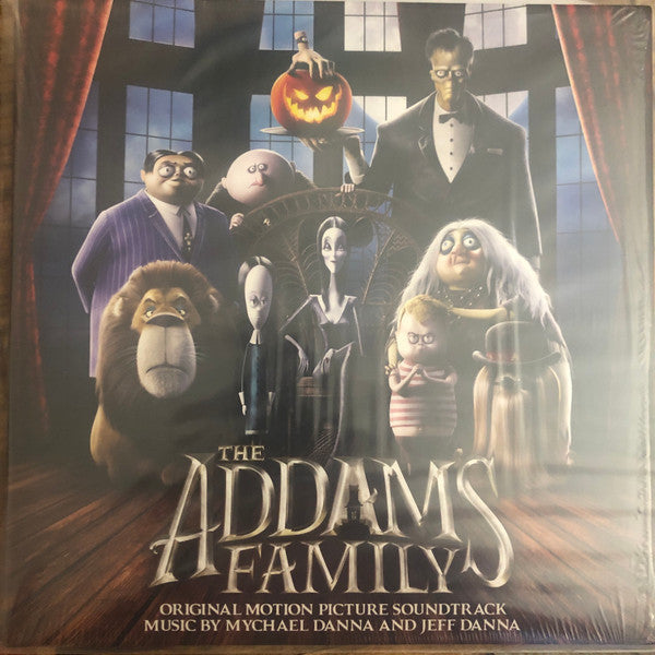 The Addams Family characters posed in front of a spooky mansion.