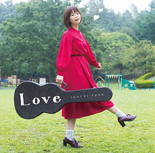 Yuka Iguchi in a red dress holding a guitar case in a grassy park.