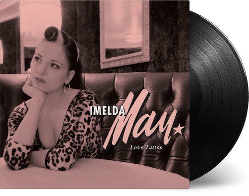 "Album cover: woman in leopard print dress sitting at a table, sepia-toned."