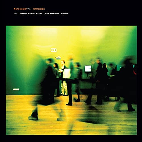 Vinyl album cover: blurred figures in a green-toned, modern interior.