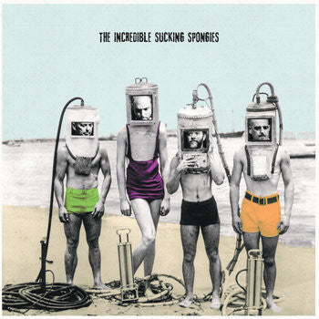 Four men in vintage diving helmets stand on a beach.