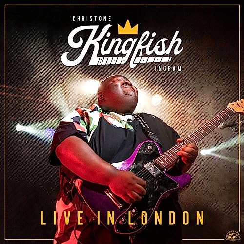 Christone Kingfish Ingram playing a purple electric guitar on stage under concert lights.