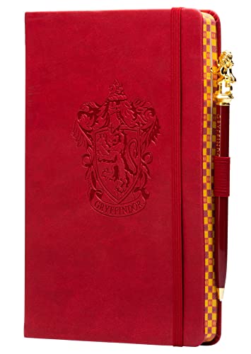 Red Gryffindor journal with gold crest and matching pen beside it.