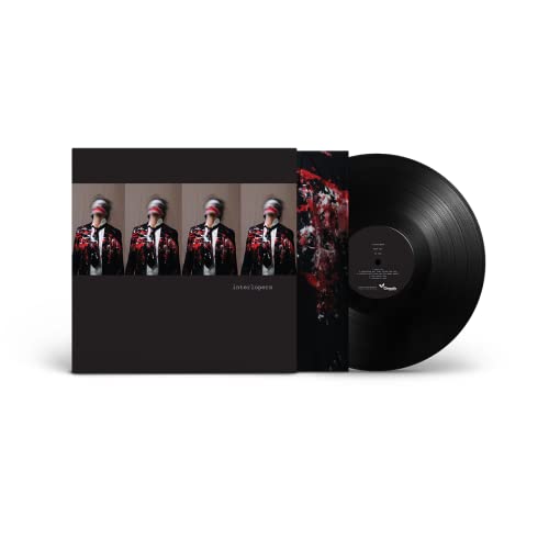 Vinyl record with album cover featuring four figures in red cloaks.